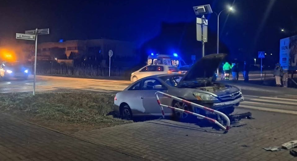 Wypadek z udziałem dwóch samochodów. Jeden z pojazdów zatrzymał się na barierkach przy chodniku