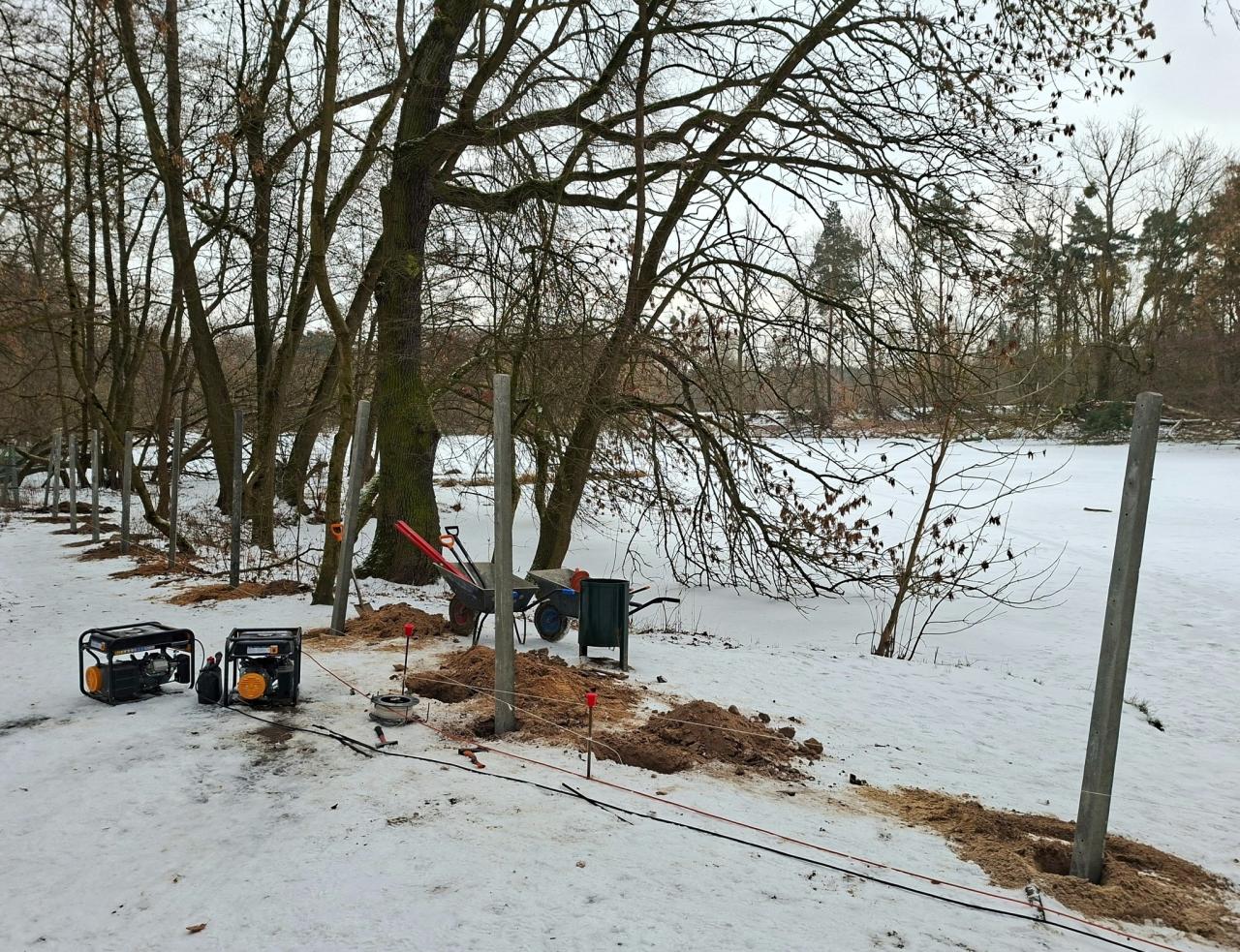 Stawiają płot nad stawem na Dębinie
