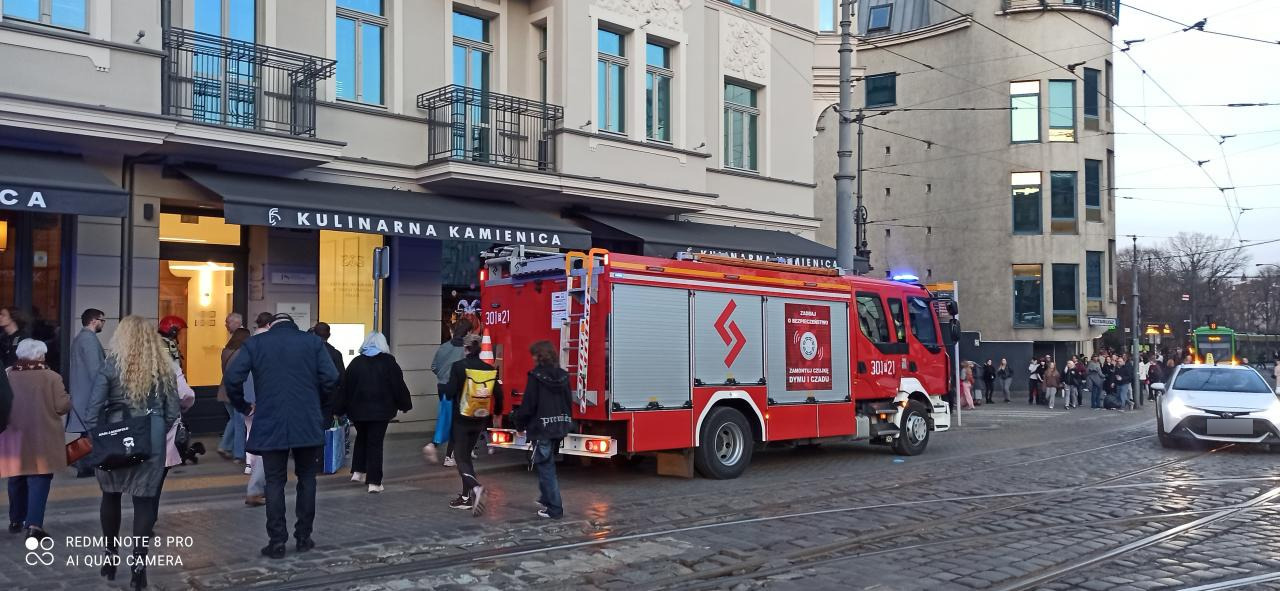 Kilka strażackich zastępów przy kamienicy w centrum Poznania